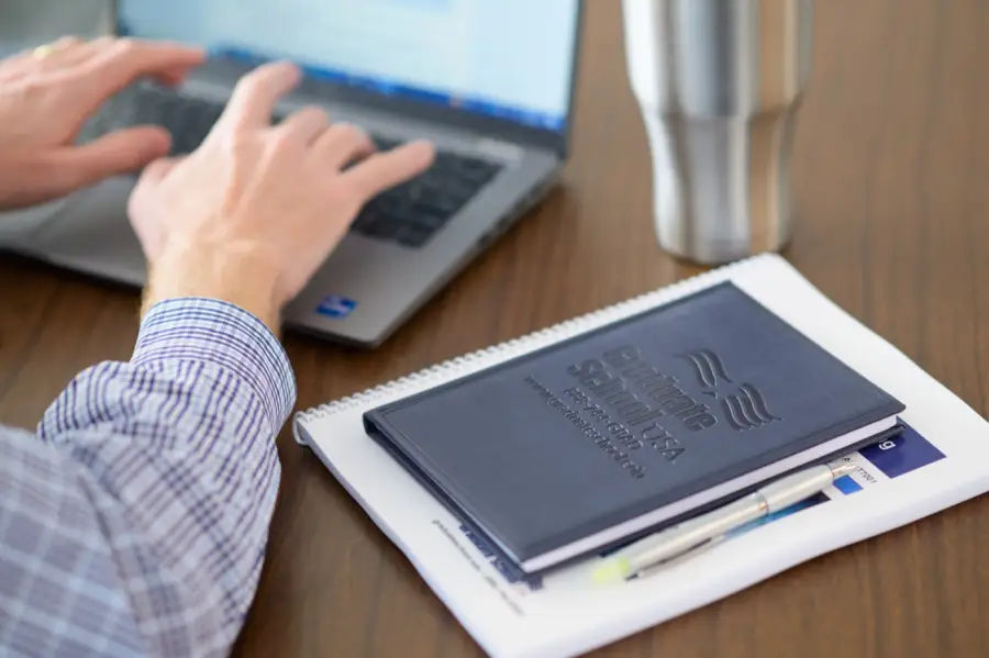 Graduate School USA course materials and a laptop